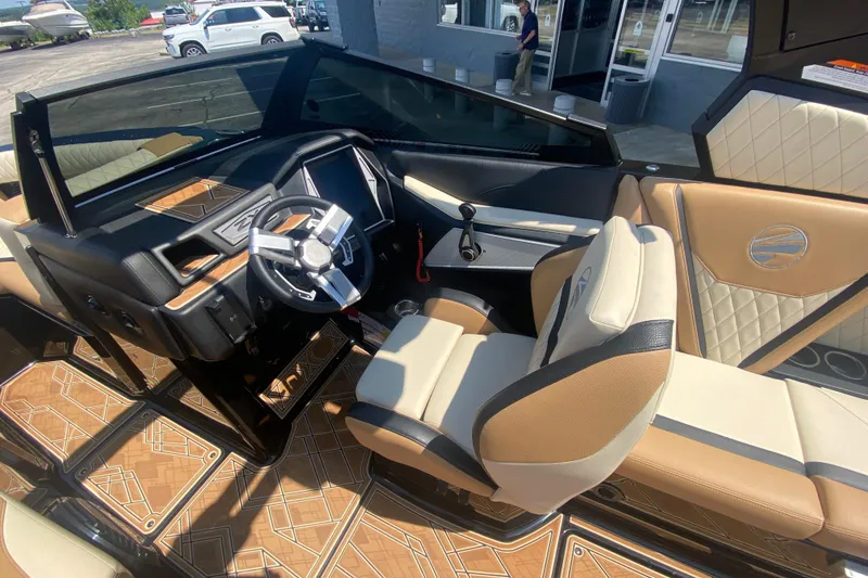 Slide: The Image of 2023 Tigé 23ZX boat interior with luxurious tan and black seating, modern dashboard, and stylish flooring. - 23
