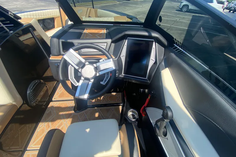 Slide: The Image of Interior of 2023 Tigé 23ZX boat featuring modern steering wheel and touchscreen display. - 25