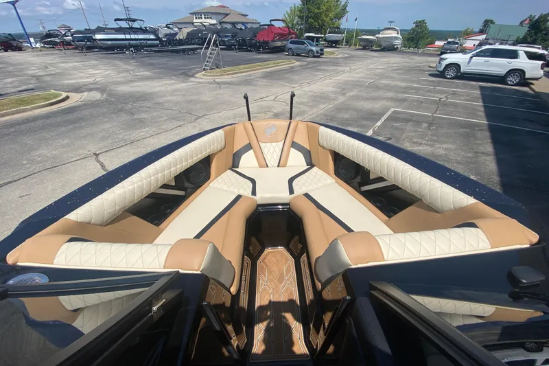 Slide: The Image of 2023 Tigé 23ZX boat interior with tan and cream seating in a parking lot. - 29