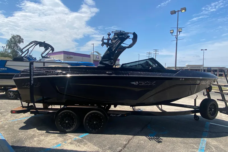 Slide: The Image of 2023 Tigé 23ZX boat on trailer in parking lot under clear sky. - 36