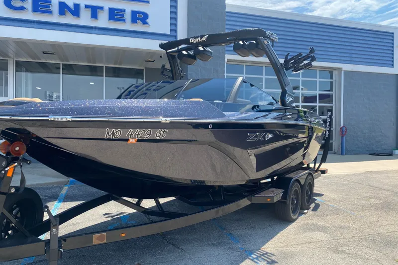 Slide: The Image of 2023 Tigé 23ZX boat on trailer outside dealership. - 38