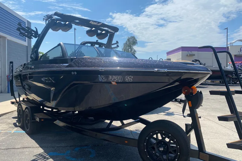 Slide: The Image of 2023 Tigé 23ZX boat on trailer, parked outdoors under a clear sky. - 39