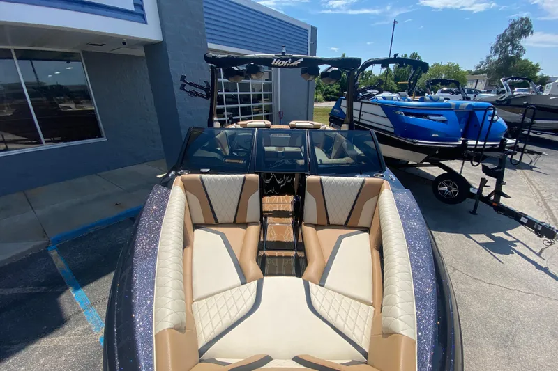 Slide: The Image of 2023 Tigé 23ZX boat with luxurious seating, parked outside a showroom. - 40