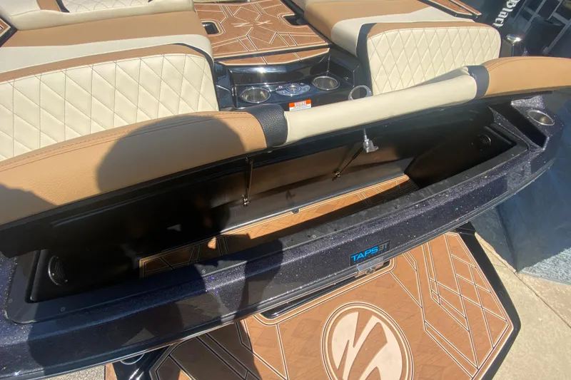 Slide: The Image of 2023 Tigé 23ZX boat interior with open storage compartment and luxury seating. - 6