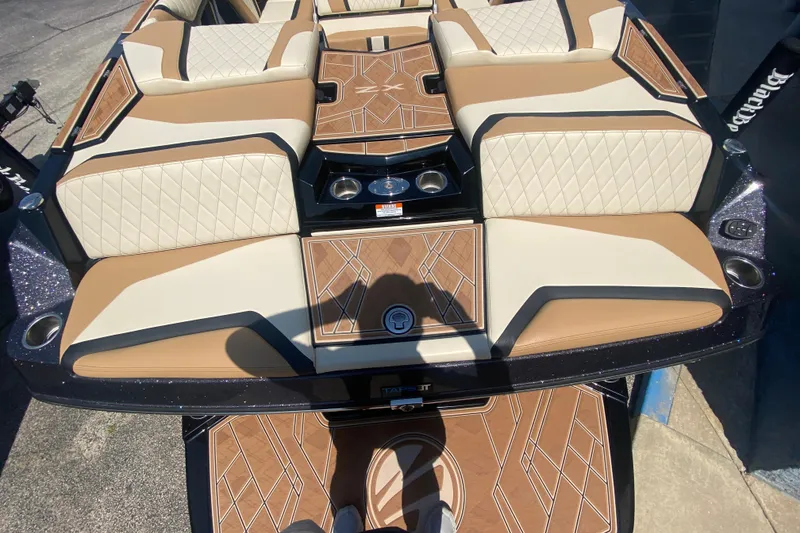 Slide: The Image of 2023 Tigé 23ZX boat interior with tan and white seating, stylish design. - 7