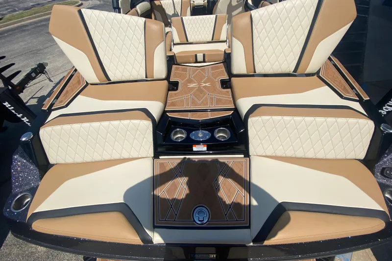 Slide: The Image of 2023 Tigé 23ZX boat interior with tan and white diamond-stitched seating and wood accents. - 9