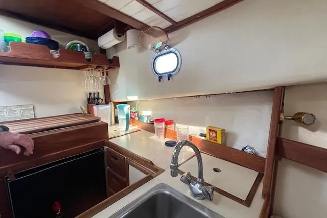 Slide: The Image of 1988 Ellis HARDTOP CRUISER kitchen with sink, shelves, and porthole window. - 20
