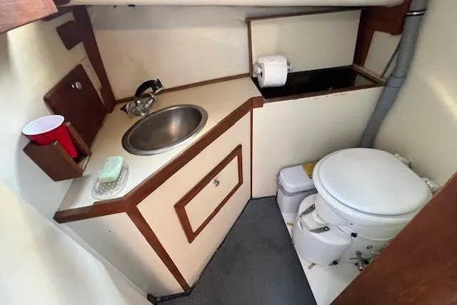 Slide: The Image of 1988 Ellis HARDTOP CRUISER boat bathroom with sink, toilet, and storage. - 23