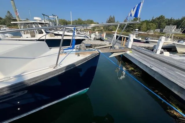 Slide: The Image of 1988 Ellis HARDTOP CRUISER docked at a marina with clear blue water. - 3