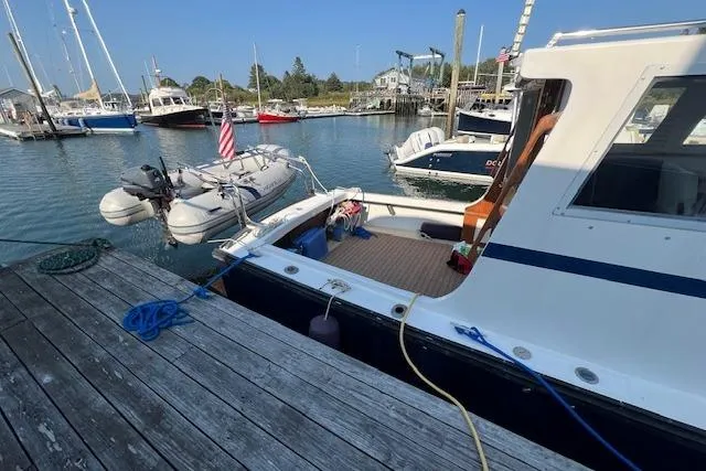 Slide: The Image of 1988 Ellis HARDTOP CRUISER docked at marina with inflatable boat and American flag. - 5