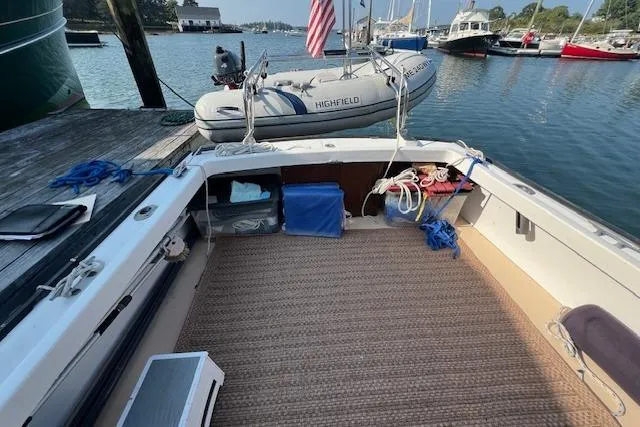 Slide: The Image of 1988 Ellis HARDTOP CRUISER boat docked with inflatable dinghy and American flag. - 6