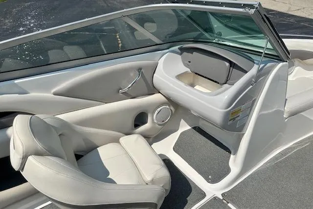 Slide: The Image of 2005 Chaparral 210 SSi boat interior with white seating and storage compartment. - 22