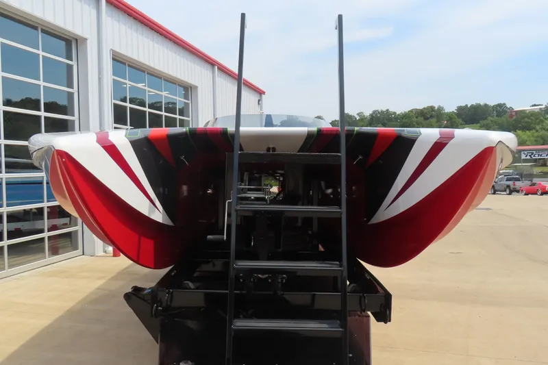 Slide: The Image of 2025 Skater 388 boat with vibrant red and white design, parked outside a garage. - 10