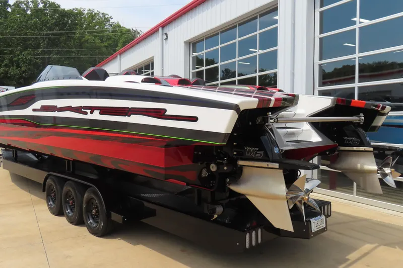 Slide: The Image of 2025 Skater 388 powerboat with bold red and black design, parked outside a garage. - 11
