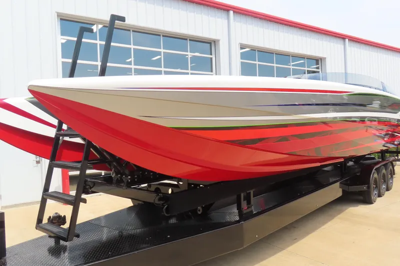 Slide: The Image of 2025 Skater 388 powerboat with vibrant red and white design on a trailer. - 2