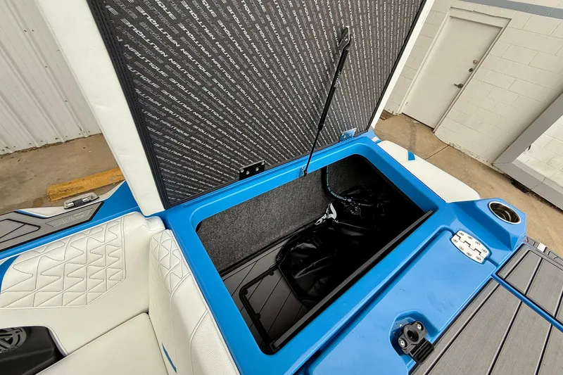 Slide: The Image of 2025 Nautique Super Air Nautique GS24 storage compartment with open hatch, showcasing interior details. - 28