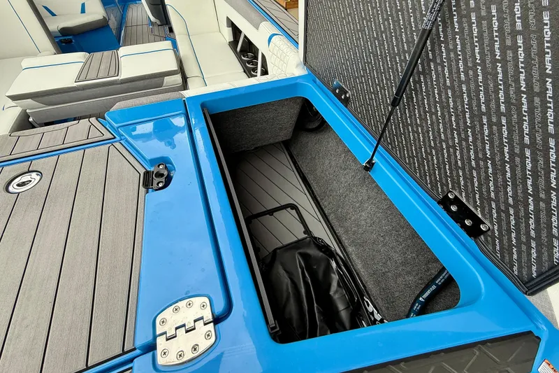 Slide: The Image of 2025 Nautique Super Air Nautique GS24 boat storage compartment, open with visible interior. - 29