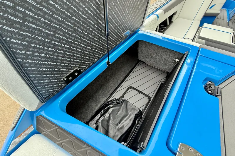 Slide: The Image of 2025 Nautique Super Air Nautique GS24 storage compartment with open lid, showcasing interior space. - 30