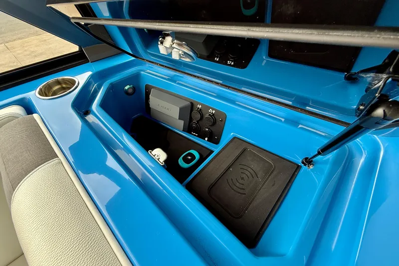 Slide: The Image of 2025 Nautique Super Air Nautique GS24 interior storage with cup holder and control panel. - 33