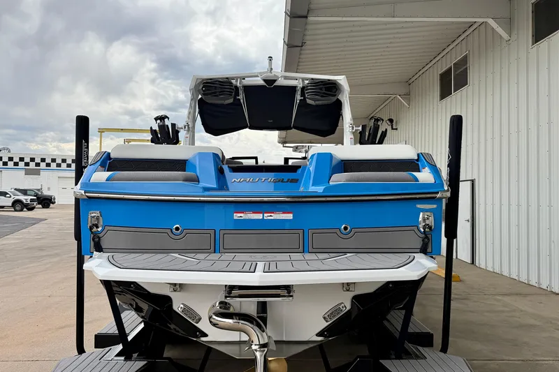 Slide: The Image of 2025 Nautique Super Air Nautique GS24 boat, blue and white, rear view at dock. - 4