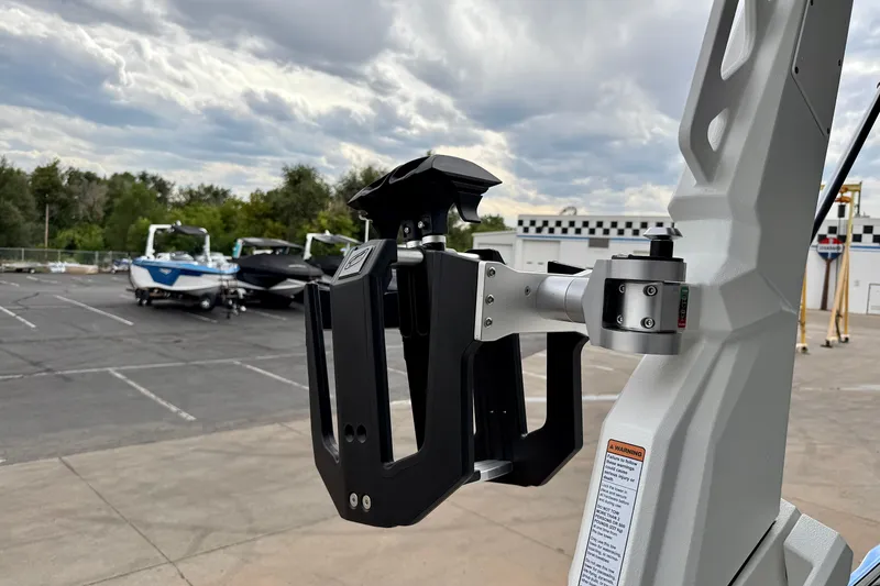 Slide: The Image of 2025 Nautique Super Air Nautique GS24 boat detail with parking lot and cloudy sky. - 40