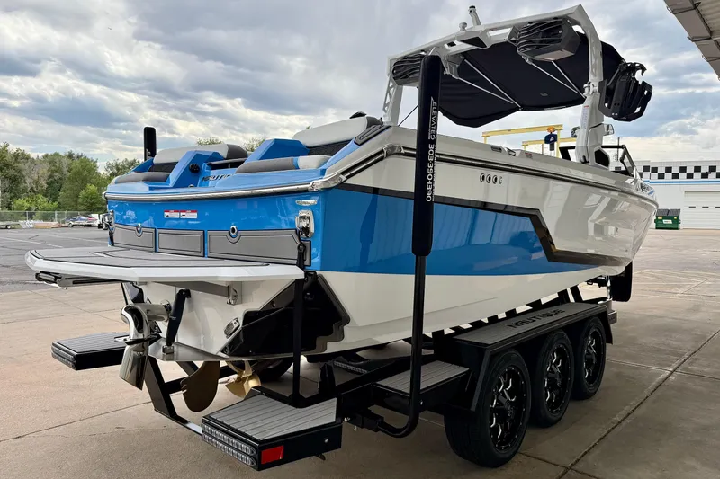 Slide: The Image of 2025 Nautique Super Air Nautique GS24 boat on trailer, blue and white design, outdoor setting. - 7