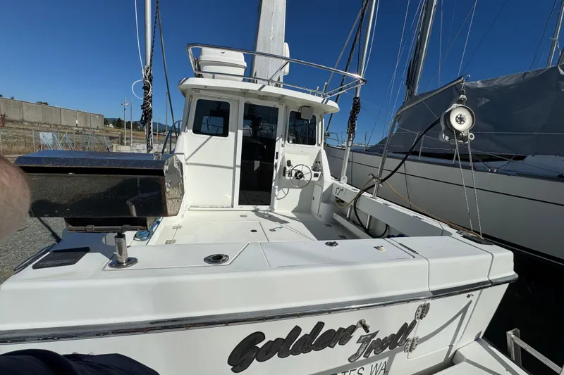 Slide: The Image of 2005 Ocean Sport Roamer 30 boat docked, featuring spacious deck and cabin. - 11