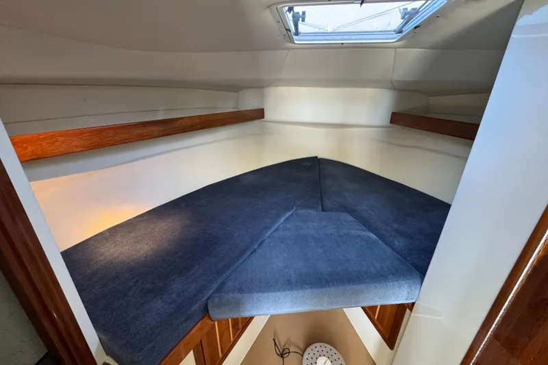 Slide: The Image of 2005 Ocean Sport Roamer 30 cabin interior with blue cushions and wooden accents. - 18