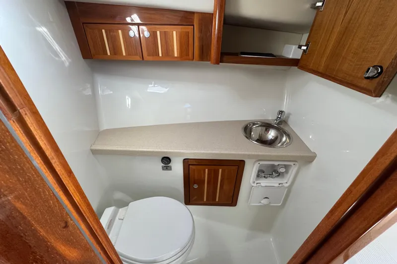Slide: The Image of Compact bathroom in 2005 Ocean Sport Roamer 30 boat with wooden cabinets and stainless steel sink. - 20