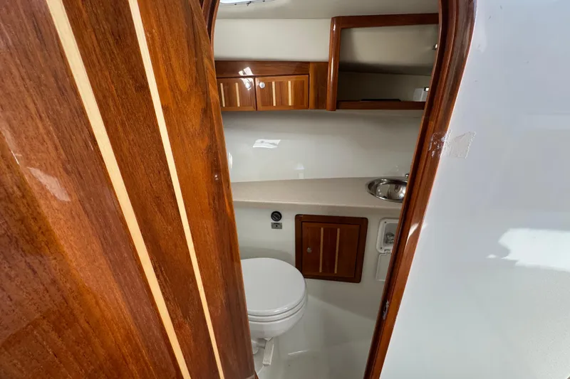 Slide: The Image of 2005 Ocean Sport Roamer 30 boat interior with wooden cabinetry and compact bathroom. - 21