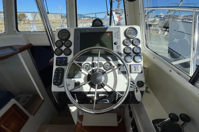 Slide: The Image of Helm of 2005 Ocean Sport Roamer 30 with navigation instruments and steering wheel. - 24