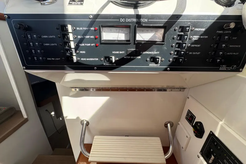 Slide: The Image of Control panel of a 2005 Ocean Sport Roamer 30 boat, featuring various switches and gauges. - 26