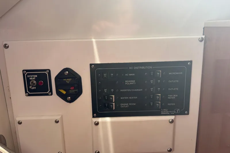 Slide: The Image of Control panel of a 2005 Ocean Sport Roamer 30 boat, featuring AC distribution switches. - 30