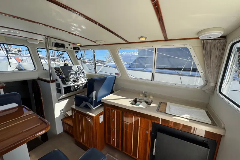Slide: The Image of Interior of 2005 Ocean Sport Roamer 30 boat with helm, seating, and kitchenette. - 32