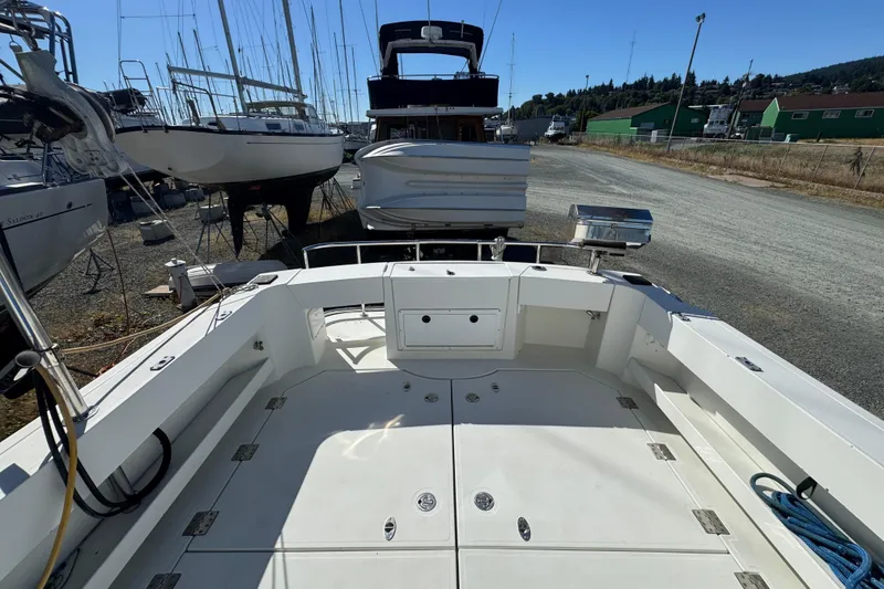 Slide: The Image of 2005 Ocean Sport Roamer 30 boat deck in a marina with surrounding vessels. - 47