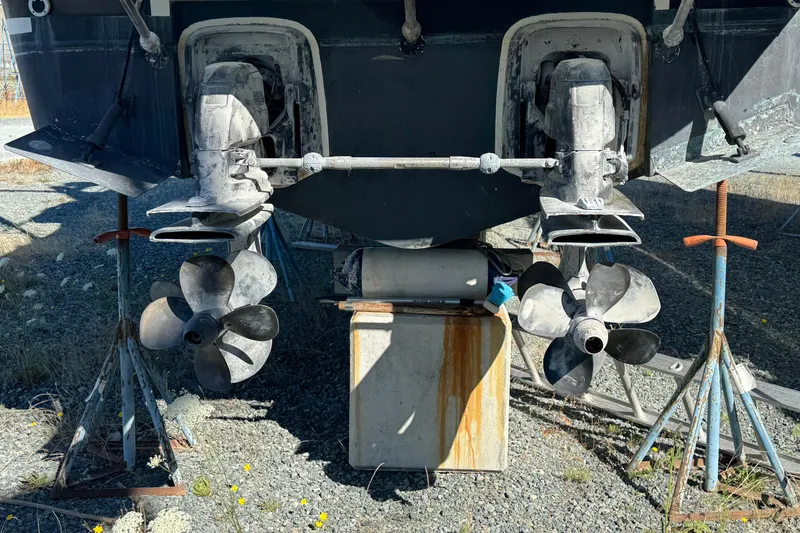 Slide: The Image of 2005 Ocean Sport Roamer 30 boat propellers and outdrives on stands, outdoor setting. - 7