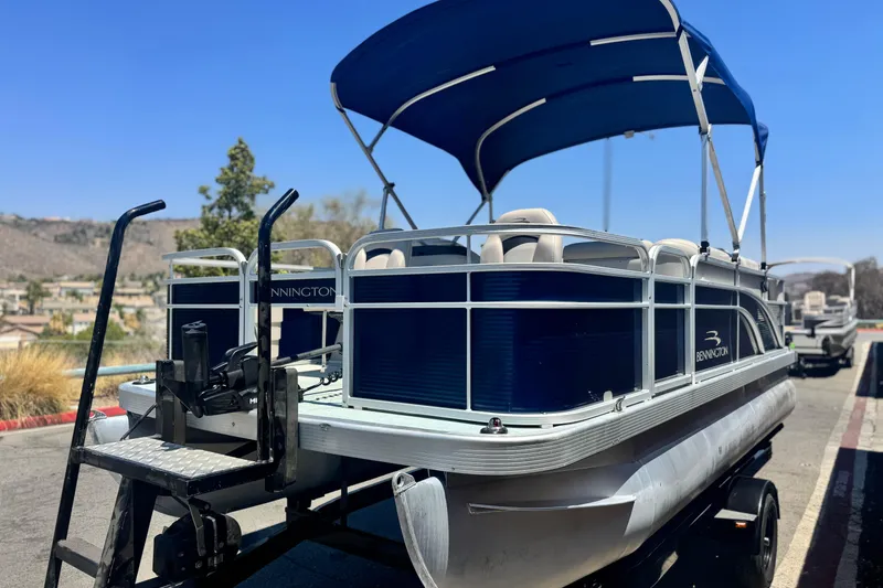 Slide: The Image of 2019 Bennington 188 SV pontoon boat with blue canopy on a trailer. - 3