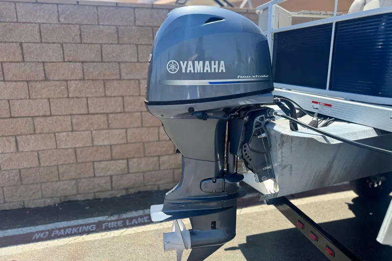 Slide: The Image of 2019 Bennington 188 SV with Yamaha four-stroke outboard motor, parked near brick wall. - 7