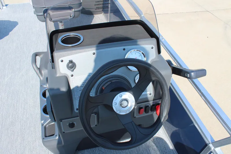 Slide: The Image of 2026 Sun Tracker Bass Buggy 18 DLX steering console with gauges and cup holder. - 15