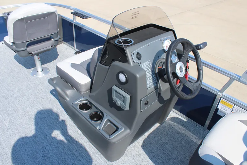 Slide: The Image of 2026 Sun Tracker Bass Buggy 18 DLX boat console with steering wheel and seating. - 18