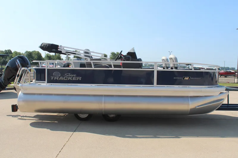 Slide: The Image of 2026 Sun Tracker Bass Buggy 18 DLX pontoon boat on display outdoors. - 5
