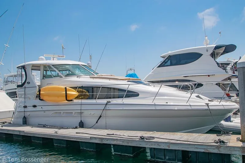 Slide: The Image of 2005 Sea Ray 390 Motor Yacht docked with kayak on side, clear sky background. - 2