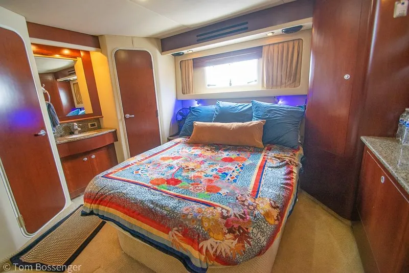 Slide: The Image of Luxurious 2005 Sea Ray 390 Motor Yacht bedroom with colorful bedding and elegant wood finishes. - 24