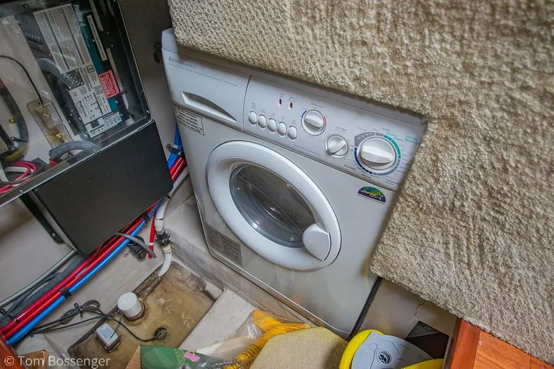 Slide: The Image of Laundry area inside 2005 Sea Ray 390 Motor Yacht, featuring a compact washing machine. - 39