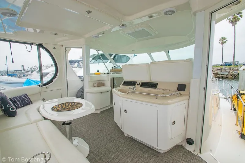 Slide: The Image of 2005 Sea Ray 390 Motor Yacht interior with seating and table, docked at marina. - 42