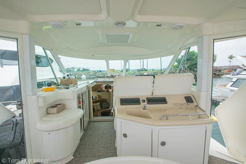 Slide: The Image of 2005 Sea Ray 390 Motor Yacht interior with helm, seating, and kitchenette. - 48