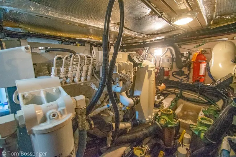 Slide: The Image of Engine room of a 2005 Sea Ray 390 Motor Yacht, showcasing complex machinery and wiring. - 69