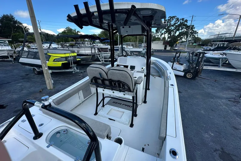 Slide: The Image of 2023 Sea Pro 219 Deep V CC boat in a marina, showcasing interior seating and console. - 12