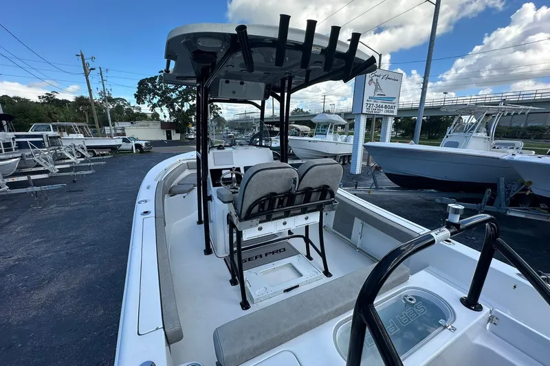 Slide: The Image of 2023 Sea Pro 219 Deep V CC boat with T-top and seating, displayed at a dealership. - 14