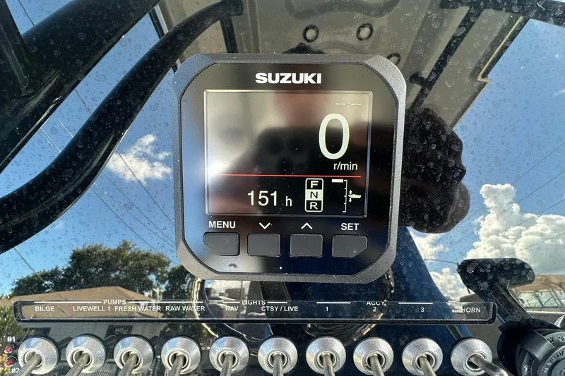 Slide: The Image of Suzuki display on 2023 Sea Pro 219 Deep V CC boat dashboard with control switches. - 26